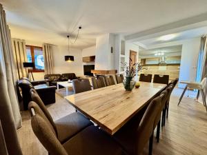 a dining room and living room with a wooden table and chairs at Terchovský dvor - Ubytovanie & wellness in Terchová