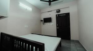 a room with a bed and a black door at Saras Lodge in Cochin
