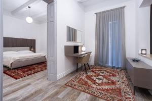 a bedroom with a bed and a desk and a bed sidx sidx sidx at Old Theatre Suites - Elba in Valletta