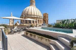 a building with a pool and a building with a dome at Old Theatre Suites - Elba in Valletta