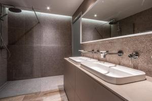 a bathroom with two sinks and a shower at Old Theatre Suites - Elba in Valletta +14 photos