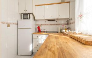a kitchen with white cabinets and a wooden counter top at Gorgeous Home In Orihuela in Villamartin