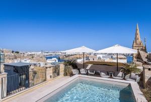 a swimming pool on a balcony with a view of the city at Old Theatre Suites - Elba in Valletta