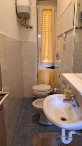a bathroom with a white sink and a toilet at Sant Antonino Metro Pozzo Strada in Turin