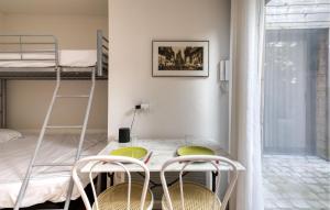 ein kleines Zimmer mit einem Tisch und 2 Etagenbetten in der Unterkunft Appartement Proche Plage in La Rochelle