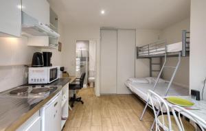 ein kleines Zimmer mit einem Etagenbett und einer Küche in der Unterkunft Appartement Proche Plage in La Rochelle