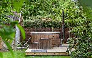 a wooden deck with a hot tub and two stools at Lovely Home In Dronningmølle With Wifi in Dronningmølle +18 photos