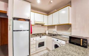 a kitchen with white cabinets and a washer and dryer at Beautiful Apartment In Canet De Berenguer in Canet de Berenguer +11 photos