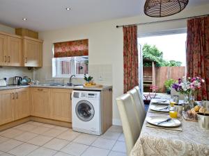 a kitchen with a washing machine in the middle of a table at Cormorant View in Weymouth