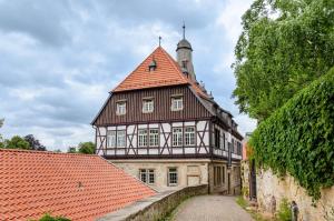 una vecchia casa con un tetto arancione e una strada di Ferienwohnung an der Ohme a Warburg