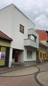 a white building with a sign on the side of it at Srdce Mesta 2 - smart apartmán Pod Lipou v centre in Gerlachov +3 photos