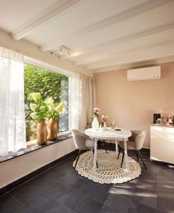 a dining room with a table and chairs and a window at B&B Antonius beej de Maas in Venlo +11 photos