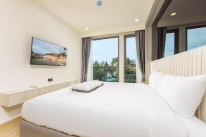 Laguna PhuketにあるModern 1-BR at The Ozone Phuket BangTao Beach by TropicLookの白いベッドルーム(大型ベッド1台、窓付) +25枚の写真