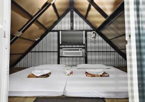 a large white bed in a small room with a tv at River Ranch Resort in Tupi