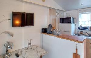 a small kitchen with a television on the wall at Gorgeous Stacaravan In Saint-Paul-Lès-Dax in Saint-Paul-lès-Dax