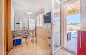 a kitchen and dining room with a table and chairs at 3 Bedroom Stunning Home In Miami Platja in Miami Platja