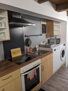 a kitchen with a sink and a washing machine at Handwerker Wohnung im Landhaus in Ramhusen