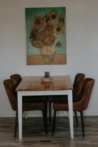 a dining room table with chairs and a painting at Stylish apartment mit Bachblick in Vallendar