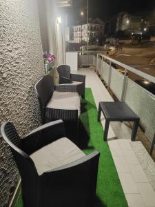a row of chairs and tables on a balcony with green grass at Palmibayhome in Palmi