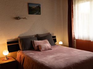 una camera da letto con un letto con due lampade sopra di Gîte dans hameau a Ugine