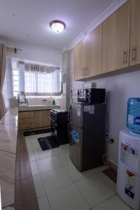 La cuisine est équipée d'un réfrigérateur et d'un évier. dans l'établissement Serene Spaces Garden Estate, à Gatunga