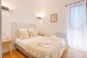 a white bedroom with a bed with towels on it at Le Sureau S30 - Le Val Joly - 300 m du lac in Eppe-Sauvage