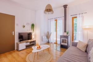 a living room with a couch and a tv at Le Sureau S30 - Le Val Joly - 300 m du lac in Eppe-Sauvage