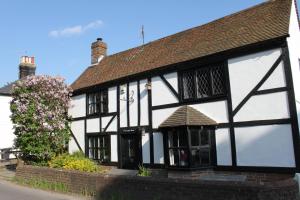 un vecchio edificio bianco e nero con un albero di B&B South Downs Way a Poynings