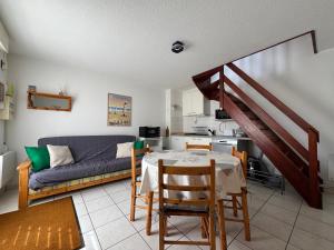 a living room with a table and a couch at L'Eclipse in Fort-Mahon-Plage