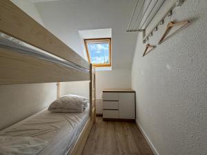 a small bedroom with a bed and a window at L'Eclipse in Fort-Mahon-Plage