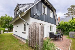 a small white house with a black roof at Haus Sommerliebe in Prerow