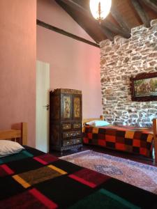 a room with two beds and a stone wall at Αρχοντικό Πανόραμα in Melívoia