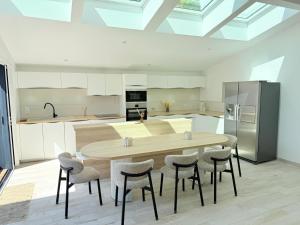 eine Küche mit einem Holztisch und einigen Stühlen in der Unterkunft Villa NORMANDY in Saint-Georges-de-Didonne