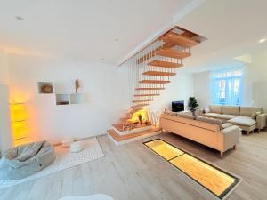 ein Wohnzimmer mit einer Couch und einer Treppe in der Unterkunft Villa NORMANDY in Saint-Georges-de-Didonne + 28 Fotos