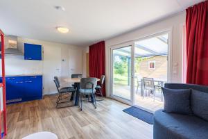 a kitchen and living room with a table and chairs at Welcome in - Chalet Bosdier, Camping de Duinhoeve Burgh-Haamstede in Burgh Haamstede