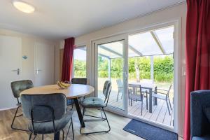 a dining room with a table and chairs at Welcome in - Chalet Bosdier, Camping de Duinhoeve Burgh-Haamstede in Burgh Haamstede