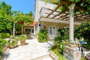 a patio with potted plants and a pergola at Apartments Milić in Mlini