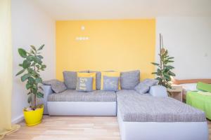 a living room with a couch and two plants at Pula Istria Apartments in Pula