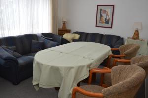 ein Wohnzimmer mit einem Tisch, Stühlen und einem Sofa in der Unterkunft Hostel am Garten in Bad Salzuflen