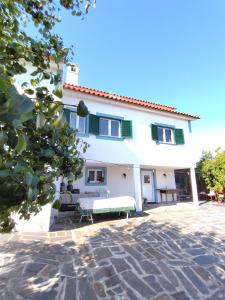 a large white house with a stone patio at Casa da Lameira in Vilar do Ruivo