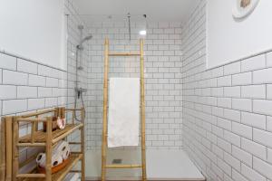 a bathroom with white subway tiles and a towel rack at Atlantic Nomad Retreat in Puerto del Rosario +17 photos