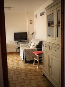 un soggiorno con un divano e una televisione di Gîte dans hameau a Ugine