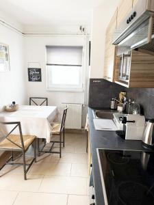 a kitchen with a table and a dining room at Juicy Private Apartments with Jacuzzi in Szentendre