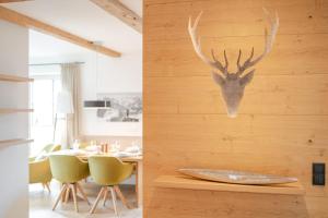 a dining room with a table and a deer head on the wall at Penthouse No9 in Oberstaufen