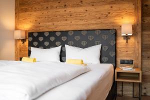 a bedroom with a large white bed and a wooden wall at Penthouse No9 in Oberstaufen +18 photos