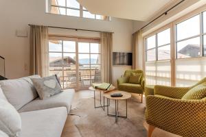 a living room with a couch and chairs and windows at Penthouse No9 in Oberstaufen
