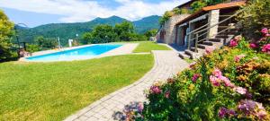 un jardín con piscina junto a una casa en schönes Ferienhäuschen in ruhiger Lage für max. 4 Personen mit Pool, en Olzano