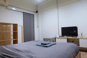 una camera con letto, TV e scrivania di The beeroom by BoonmeeApt a Sathani Sam Sen