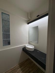 un bagno con un lavandino e uno specchio su un bancone di The beeroom by BoonmeeApt a Sathani Sam Sen