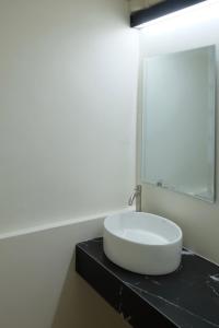 un lavandino bianco su un bancone nero in bagno di The beeroom by BoonmeeApt a Sathani Sam Sen